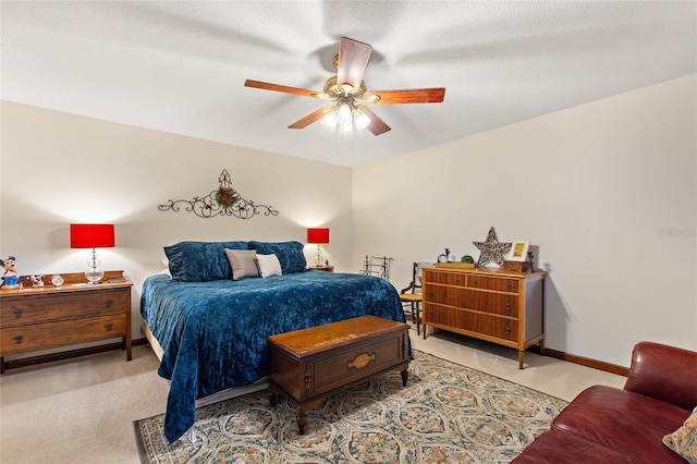 bedroom with a textured ceiling, ceiling fan, and light carpet