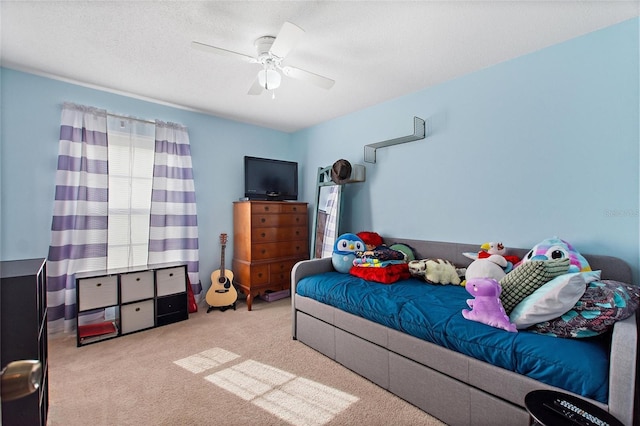 carpeted bedroom featuring ceiling fan and a textured ceiling