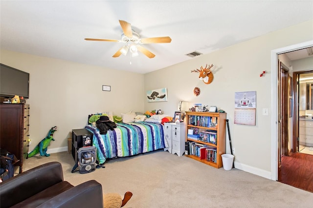 bedroom with light carpet, connected bathroom, and ceiling fan