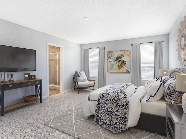 carpeted bedroom featuring a textured ceiling and connected bathroom