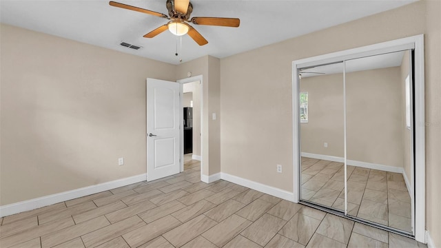 unfurnished bedroom with ceiling fan and a closet