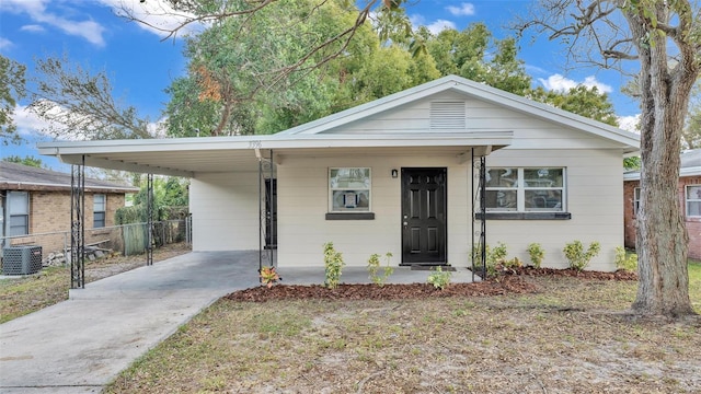 view of front of home with a carport, central air condition unit, and a front lawn