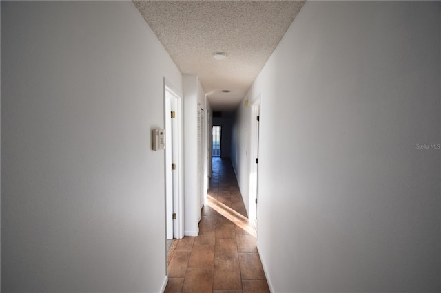 hall with dark hardwood / wood-style flooring and a textured ceiling