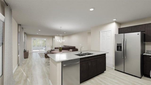 kitchen featuring sink, light hardwood / wood-style flooring, an island with sink, dark brown cabinetry, and stainless steel appliances