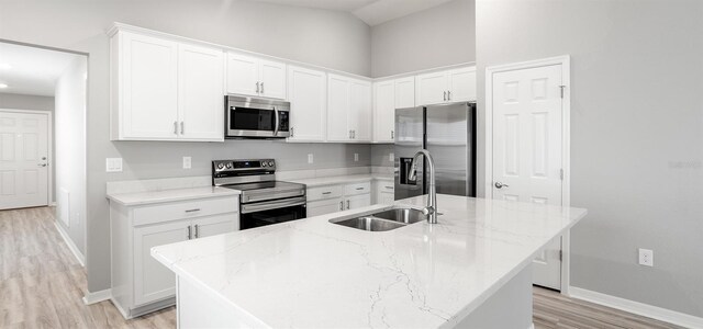 3146 Laurel Oak Ln, Winter Haven, FL 33884 - kitchen featuring appliances with stainless steel finishes, a sink, baseboards, light wood-style floors, and lofted ceiling