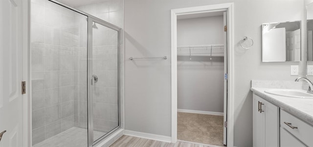 3146 Laurel Oak Ln, Winter Haven, FL 33884 - full bathroom featuring a shower stall, a walk in closet, vanity, and baseboards