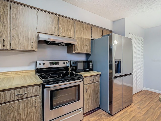4531 Blossom Blvd Unit 4531, Zephyrhills, FL 33542 - kitchen featuring stainless steel appliances, a textured ceiling, and light hardwood / wood-style floors