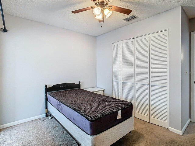 4531 Blossom Blvd Unit 4531, Zephyrhills, FL 33542 - bedroom featuring ceiling fan, a closet, carpet floors, and a textured ceiling