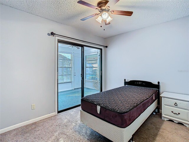 4531 Blossom Blvd Unit 4531, Zephyrhills, FL 33542 - bedroom featuring access to exterior, ceiling fan, carpet floors, and a textured ceiling