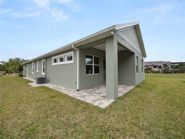 view of home's exterior with central air condition unit, a yard, and a patio