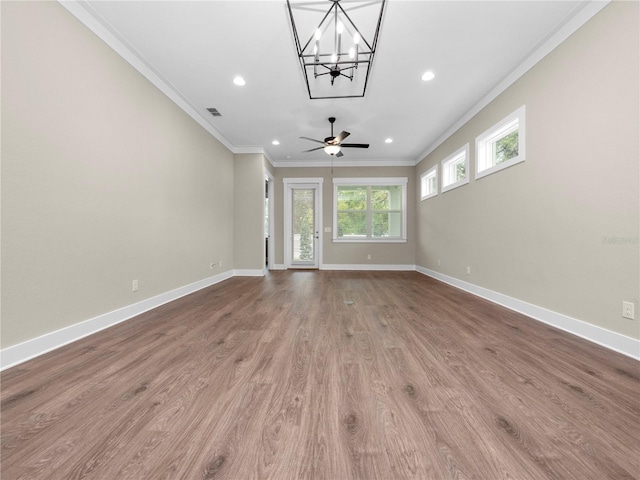 unfurnished living room featuring hardwood / wood-style floors, ceiling fan with notable chandelier, and crown molding