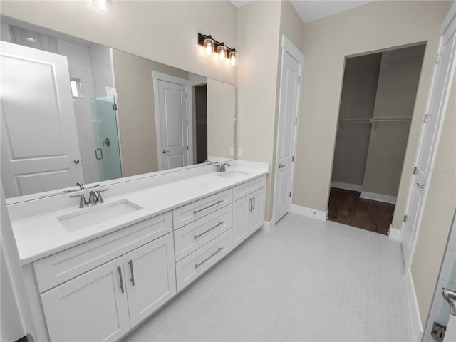 bathroom with tile patterned flooring, vanity, and a shower with door