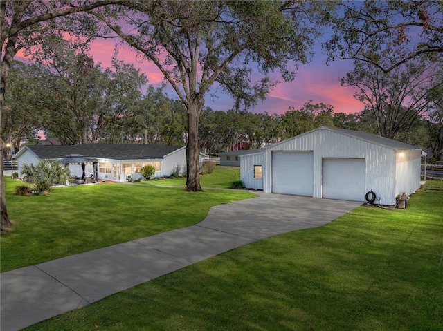 view of front facade featuring a yard, a garage, and an outdoor structure