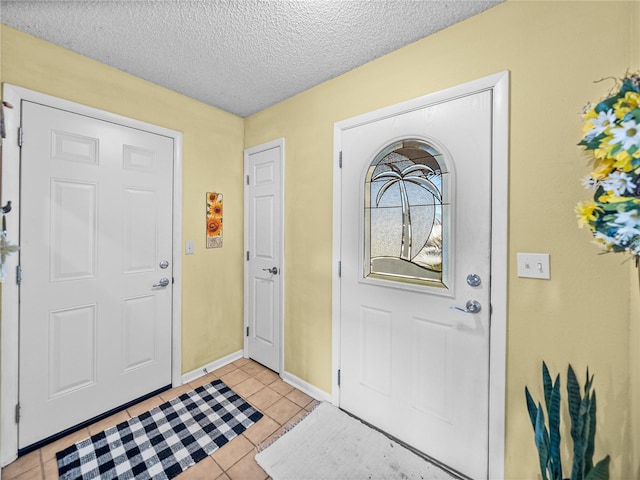 foyer entrance with light tile patterned floors and a textured ceiling