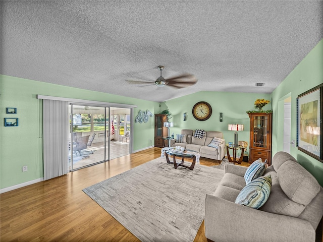 living room featuring ceiling fan, light hardwood / wood-style floors, and vaulted ceiling