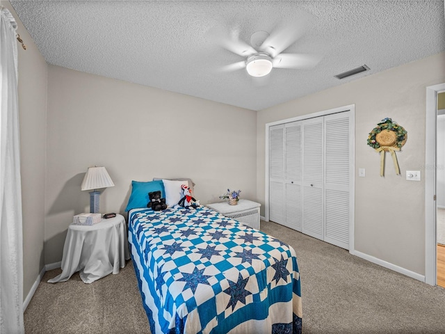 carpeted bedroom featuring ceiling fan, a textured ceiling, and a closet