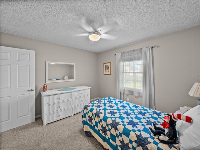 bedroom with ceiling fan, light colored carpet, and a textured ceiling