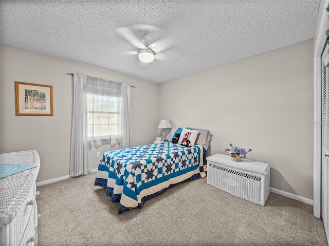 carpeted bedroom with ceiling fan, a closet, and a textured ceiling