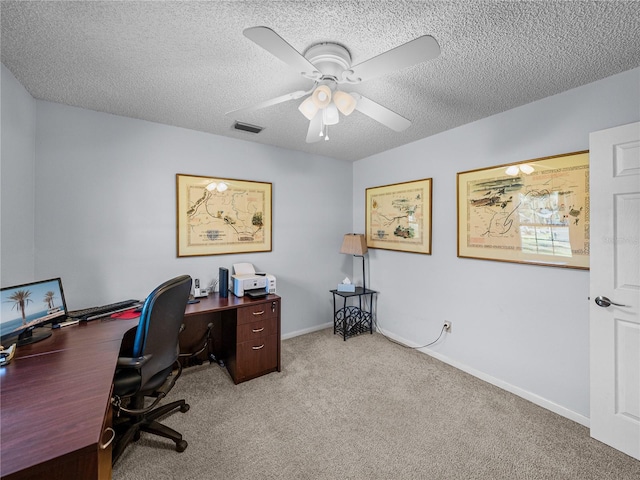 home office with a textured ceiling, ceiling fan, and light carpet