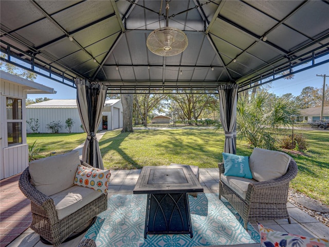 view of patio / terrace featuring a gazebo, a fire pit, and an outbuilding