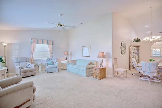 carpeted living room featuring ceiling fan with notable chandelier and vaulted ceiling