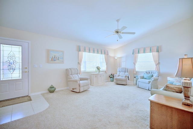 carpeted living room with ceiling fan and vaulted ceiling