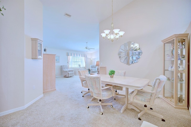 carpeted dining area featuring ceiling fan with notable chandelier and high vaulted ceiling