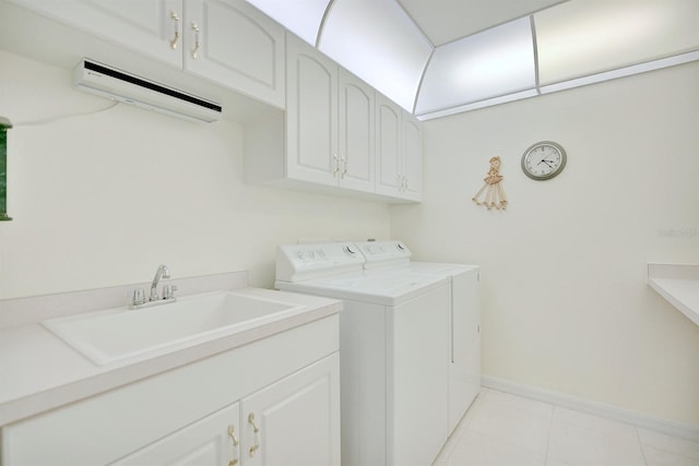 washroom with cabinets, light tile patterned flooring, washer and clothes dryer, and sink