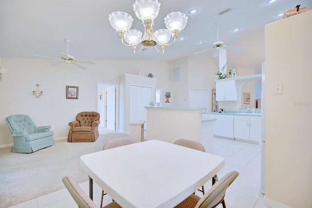 dining space featuring ceiling fan with notable chandelier, light colored carpet, lofted ceiling, and sink