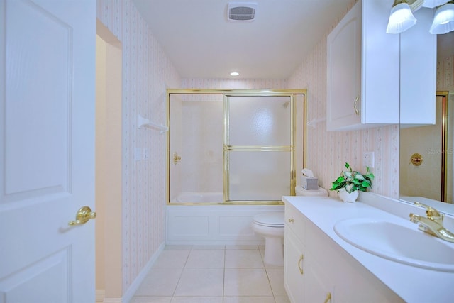 full bathroom featuring toilet, vanity, tile patterned floors, and bath / shower combo with glass door