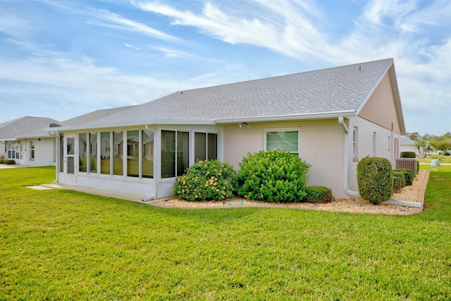 rear view of house with a lawn and a sunroom