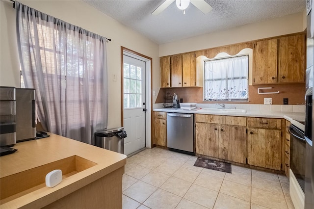 kitchen featuring stainless steel dishwasher, a textured ceiling, ceiling fan, sink, and black / electric stove