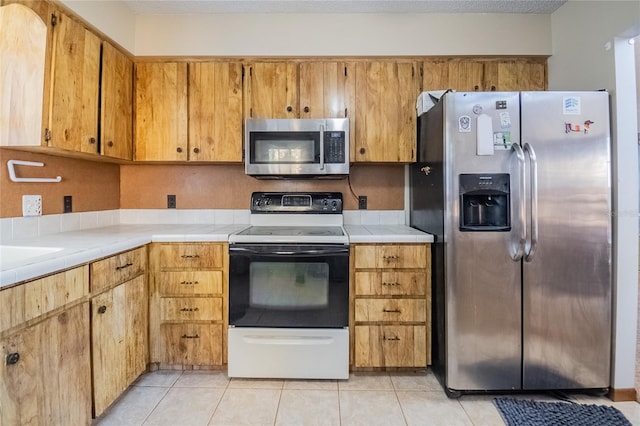 kitchen with light tile patterned floors and stainless steel appliances