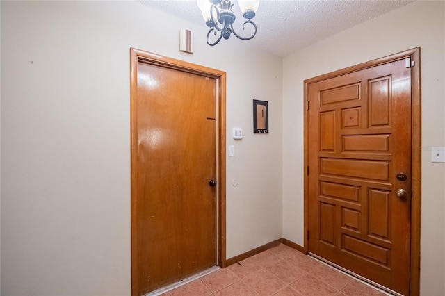 doorway to outside featuring a textured ceiling and a notable chandelier