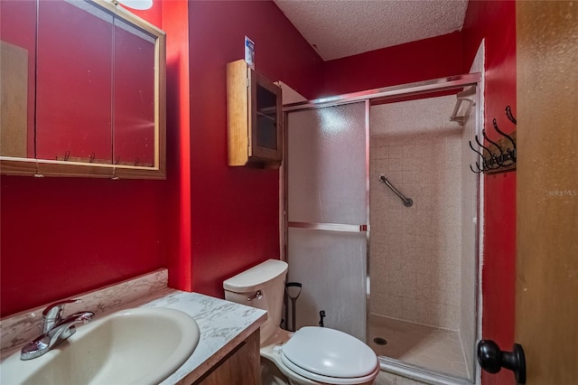 bathroom with vanity, a shower with shower door, a textured ceiling, and toilet