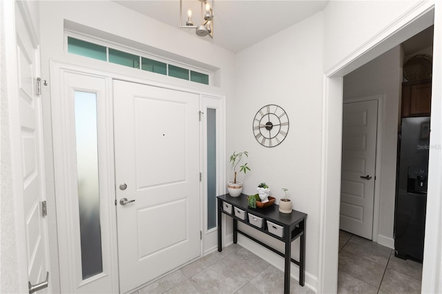 foyer with light tile patterned floors and an inviting chandelier