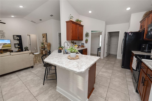 kitchen with light tile patterned flooring, sink, lofted ceiling, and black appliances