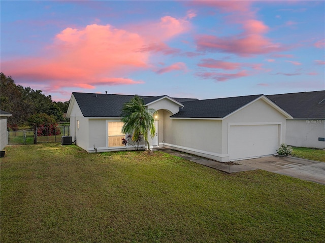 view of front of house featuring a lawn, cooling unit, and a garage