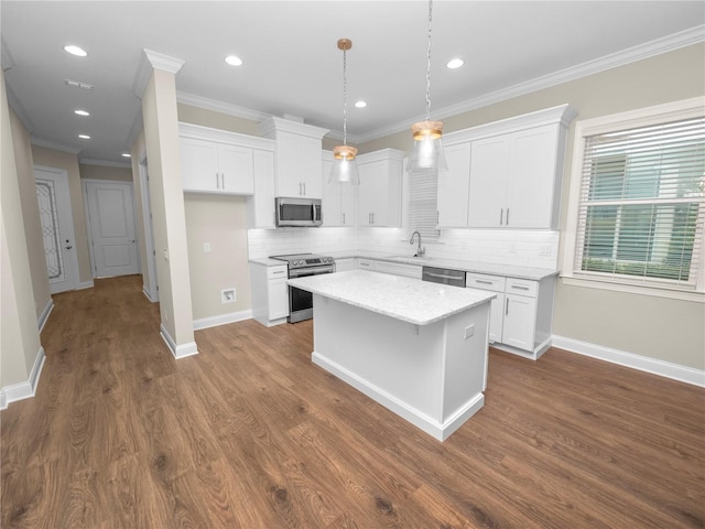 kitchen with a kitchen island, white cabinetry, stainless steel appliances, sink, and hanging light fixtures