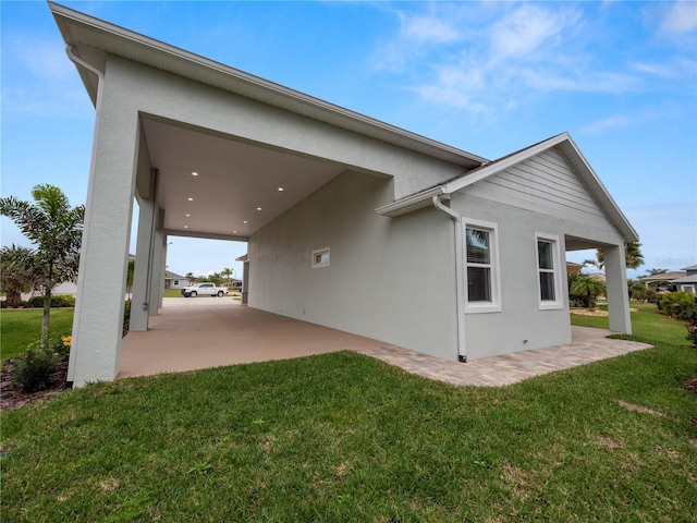 view of side of property with a patio area and a yard