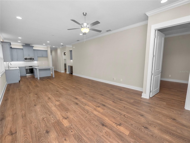 unfurnished living room with ceiling fan, dark hardwood / wood-style flooring, sink, and crown molding