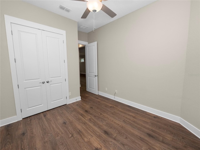 unfurnished bedroom with ceiling fan, dark hardwood / wood-style flooring, and a closet