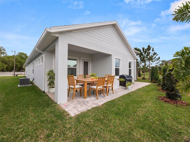 rear view of property with central air condition unit, a yard, and a patio