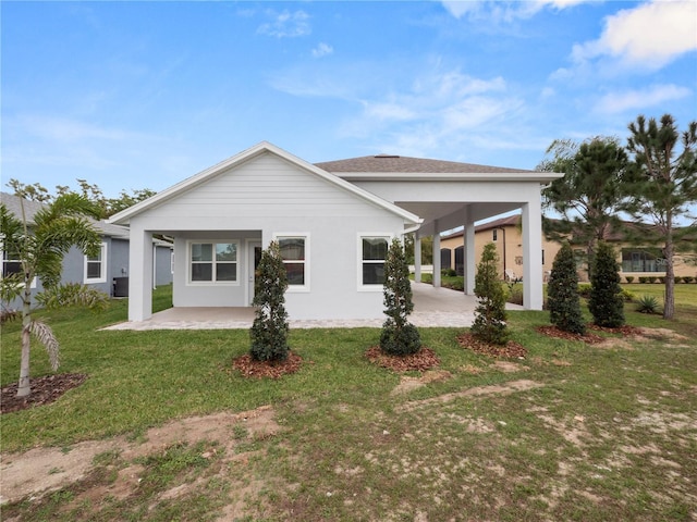 back of house featuring a lawn and a carport