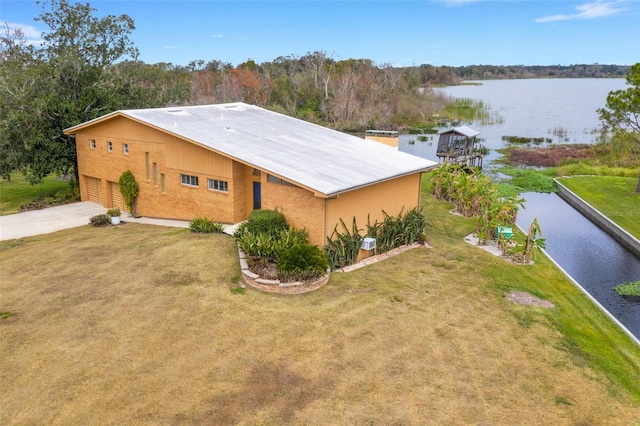 exterior space featuring a lawn, a garage, and a water view