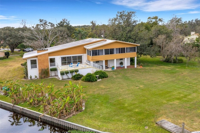 view of front of house featuring a front yard and a sunroom