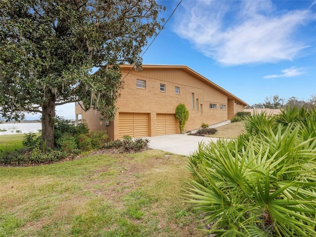 view of side of home featuring a yard and a garage