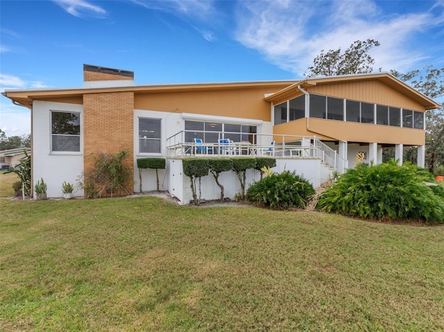 back of property with a yard and a sunroom