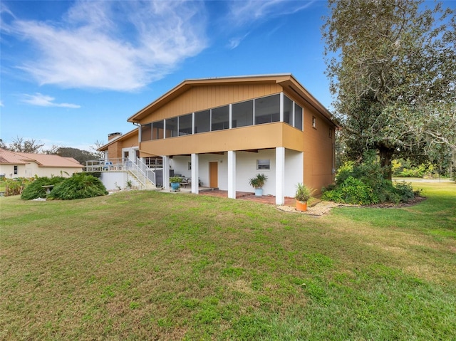 back of house featuring a yard and a sunroom