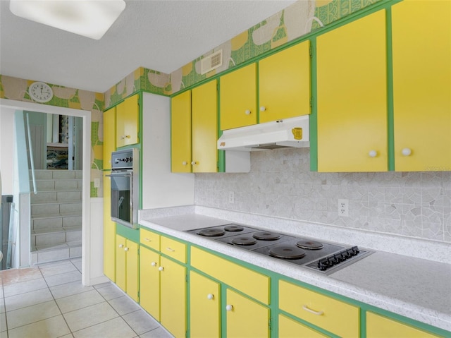 kitchen with cooktop, light tile patterned flooring, and oven